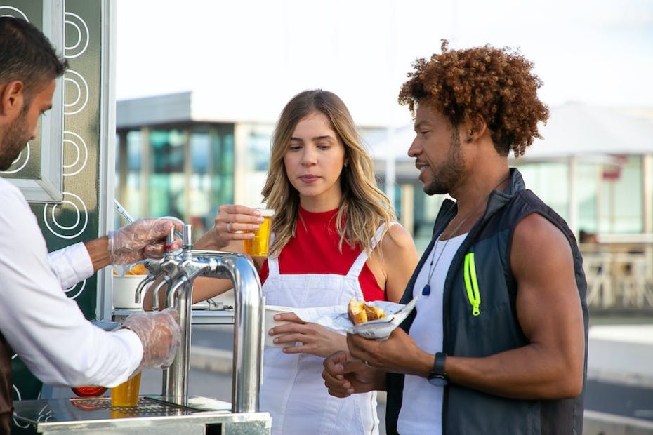 Seller pouring beer to diverse couple