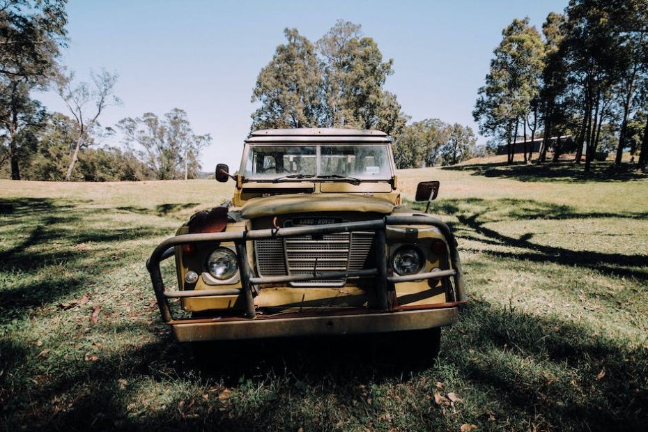 Grunge abandoned car left on grassy meadow